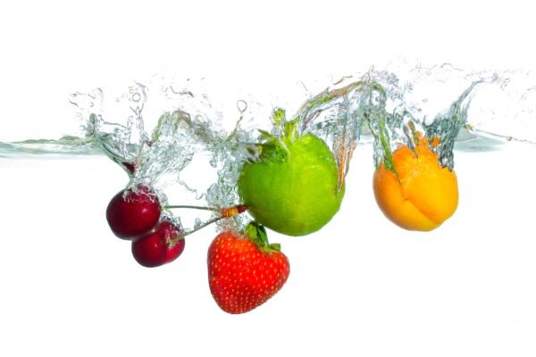 Assorted fresh fruits including cherries, strawberry, lime, and apricot splashing into water
